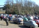 Image description - Morris and Austin cars gather on the old banked race track at Brooklands